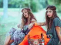 Dwie dziewczyny w stylu boho, idealne inspiracje na imprezę w stylu lat 70 jak się ubrać. Wianki, kwieciste sukienki i kolorowe dodatki.