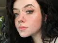 Dziewczyna z licznymi kolczykami: w nosie, ustach, brodzie i na czole. Wyróżnia się anti eyebrow piercing.