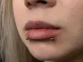 Cyber bites piercing na ustach, podkreślający ich kształt.