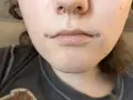 Dahlia piercing zdobi usta, dodając odrobinę buntu.