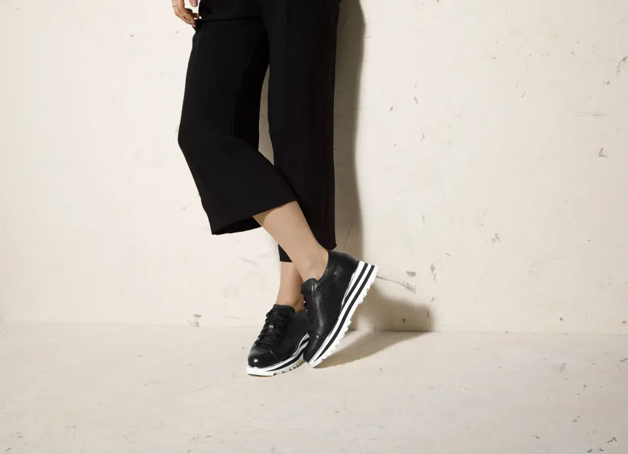 Czarne sneakersy na platformie świetnie komponują się z szerokimi spodniami 3/4, tworząc stylowy look.