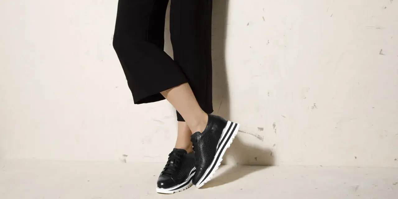 Czarne sneakersy na platformie świetnie komponują się z szerokimi spodniami 3/4, tworząc stylowy look.