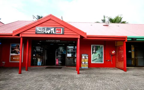 Sklep Quiksilver, znanej firmy odzieżowej dla surferów, z czerwonym logo i ofertą "Locker Hire".