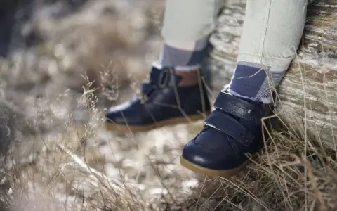 Granatowe, zimowe buty dziecięce na rzepy i sznurowadła, z futerkiem w środku. Wygodne i stylowe, idealne na jesienne i zimowe przygody. Różne marki butów oferują podobne modele.