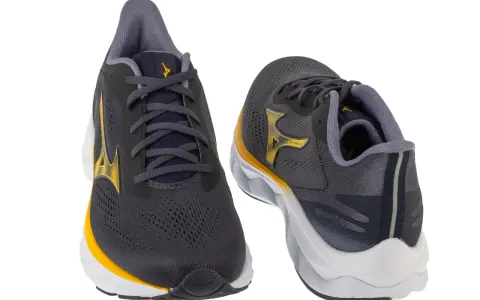 Dwa buty do biegania Mizuno w kolorze grafitowym z żółtymi akcentami. Mizuno to znana firma sportowa.