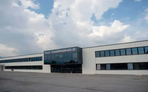 Nowoczesny budynek z logo F.LLI CAMPAGNOLO. To właśnie ta firma produkuje wysokiej jakości komponenty rowerowe.