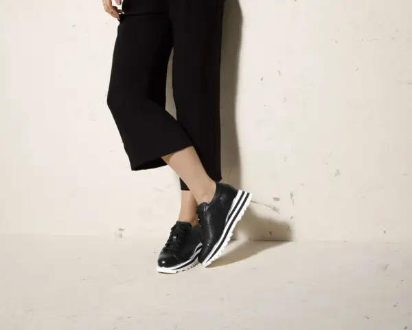 Czarne sneakersy na platformie świetnie komponują się z szerokimi spodniami 3/4, tworząc stylowy look.
