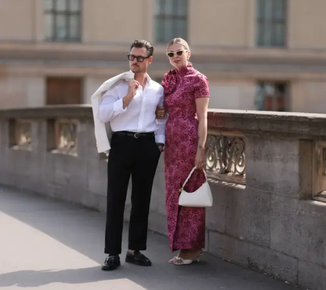 Elegancka para, która wie, jak się ubrać do teatru. On w białej koszuli i czarnych spodniach, ona w kwiecistej sukni.