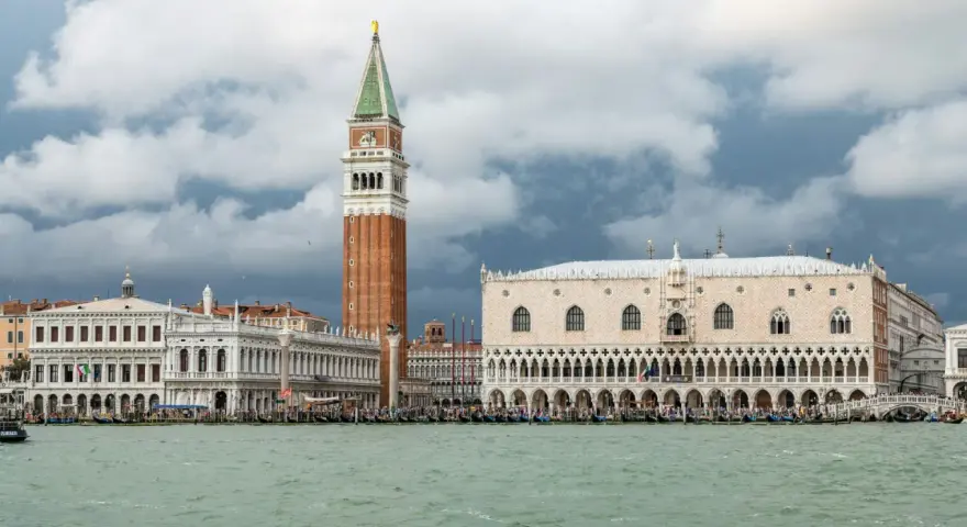 Weneckie budowle, w tym Pałac Dożów i Kampanila, na tle burzowych chmur. Venezia to miasto, które zachwyca.