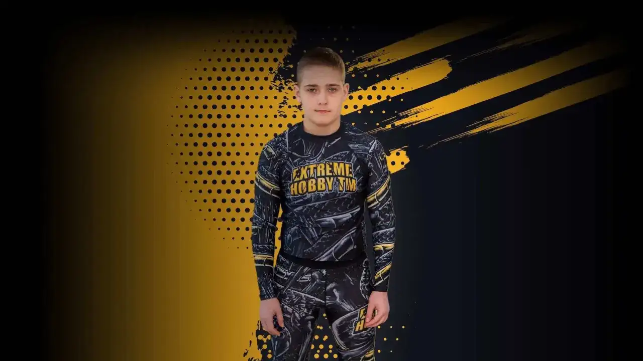 Młody zawodnik w stroju sportowym marki Extreme Hobby. Wzory na odzieży nawiązują do motywów bojowych, idealne dla miłośników sportów walki i aktywnego stylu życia.